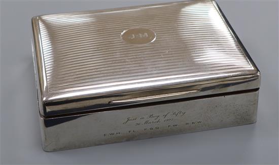 A Mappin & Webb engine-turned silver cigarette box, initialled and with presentation inscription 17.7cm.